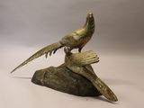 une statue en bronze représentant deux oiseaux perchés sur un rocher