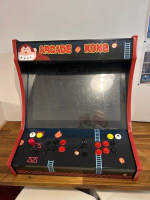 a small arcade machine sitting on top of a wooden table