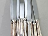 five knives on the table next to each other