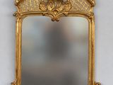 an image of a gold framed mirror hanging on a wall