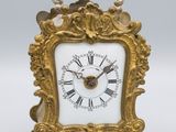 une horloge en or avec des chiffres romains sur le cadran