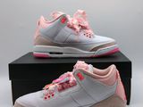 une paire de baskets blanches et roses posée sur une boîte noire