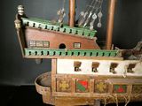 a wooden model of a pirate ship on a stand