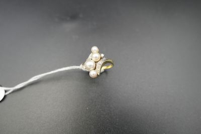 un gros plan sur une paire de boucles d'oreilles ornées de perles, posées sur une surface noire