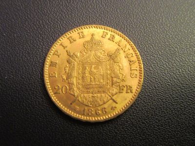 a close up of a gold coin on a black surface