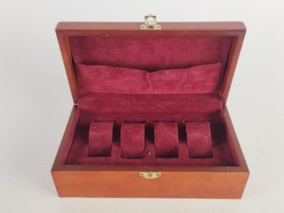 a close up of a wooden box with a watch inside of it