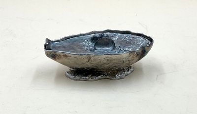 un bol en argent orné d'un oiseau sur un fond blanc