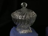 a glass bowl with a lid sitting on a blue cloth