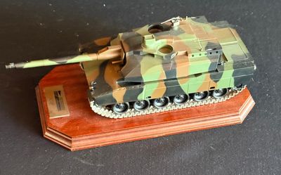 une petite maquette de char d'assaut posée sur un socle en bois