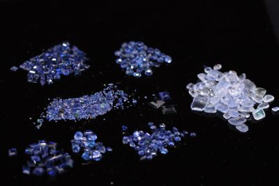 a pile of blue and white crystals on a black surface