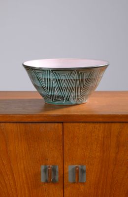 a bowl that is sitting on top of a cabinet