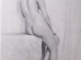 an old black and white photo of a naked woman sitting on a ledge