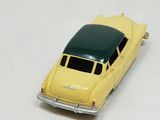 a yellow toy car that is sitting on a white surface