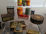 many different tins on display on a clear shelf