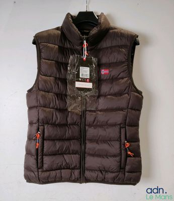 un gros plan sur un gilet suspendu à un cintre accroché au mur