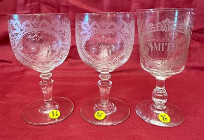 trois verres à vin vides posés les uns à côté des autres sur une nappe rouge