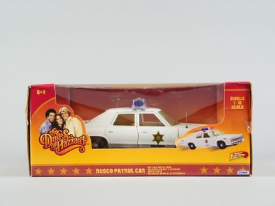 une petite voiture de police dans une boîte, posée sur une surface blanche