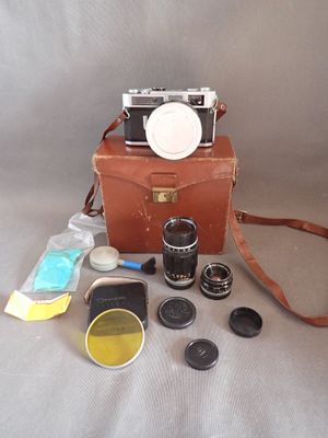 a brown case with a camera, lens, and other items on it