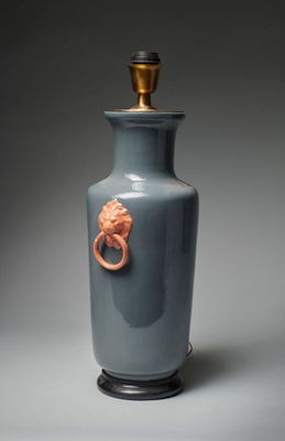 un vase bleu orné d'une tête de lion dorée