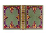 un livre vert aux bords dorés, avec une couverture rouge et jaune