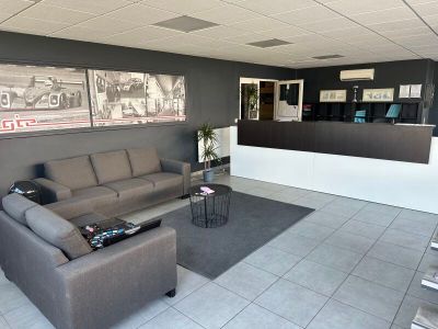 a couch and two chairs in a room with pictures on the wall