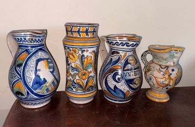 cinq vases posés sur une table, avec un mur en arrière-plan