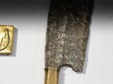a knife that is laying on a table next to a piece of metal