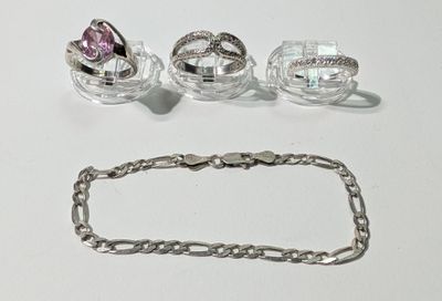 trois bagues et un bracelet posés sur une table