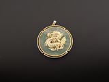 l'image d'un pendentif doré et vert orné d'un dragon