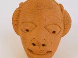 une sculpture en argile représentant le visage d'un homme sur une surface blanche