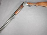 un gros plan d'un fusil à crosse en bois posé sur une chaise