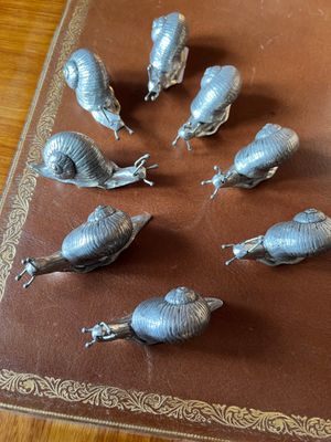 six escargots posés sur un livre posé sur la table