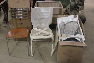 de nombreuses caisses et chaises dans une pièce où des gens les regardent
