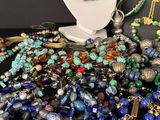 many different colored beads and necklaces displayed on a table