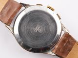 a close up of a watch on a white surface