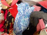 a pile of clothes and hats sitting on a bed