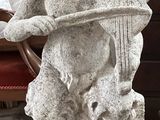 une statue représentant un ours tenant une harpe posée sur une table