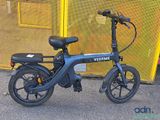 an image of a black electric bike parked in front of a yellow fence