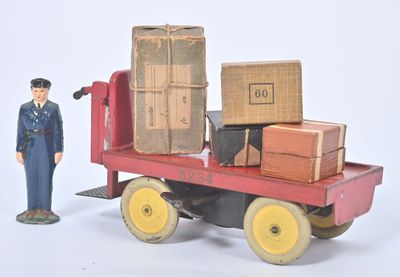 un petit bonhomme en jouet qui se tient à côté d'un petit camion en jouet