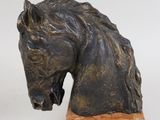 sculpture of a horse head on a wooden base on a white background