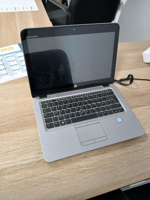un ordinateur portable posé sur un bureau en bois dans un bureau