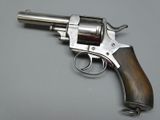 a gun with a wooden handle on a gray surface