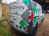 a van parked in front of a building with a sign on it