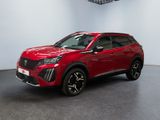 Un SUV rouge est garé dans une grande pièce.