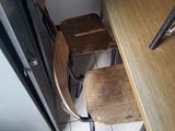 two wooden chairs and a table in a small room