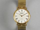 a close up of a gold wrist watch with roman numerals