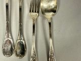 a lot of silver spoons and spoons on the table