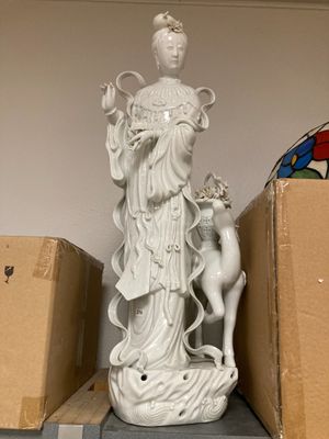 a statue of a woman and a deer on a shelf