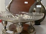 a silver plate on a table with a mirror in the background