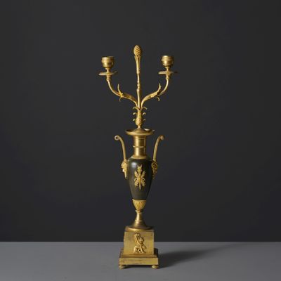 an antique brass candelabra with three candles on a stand
